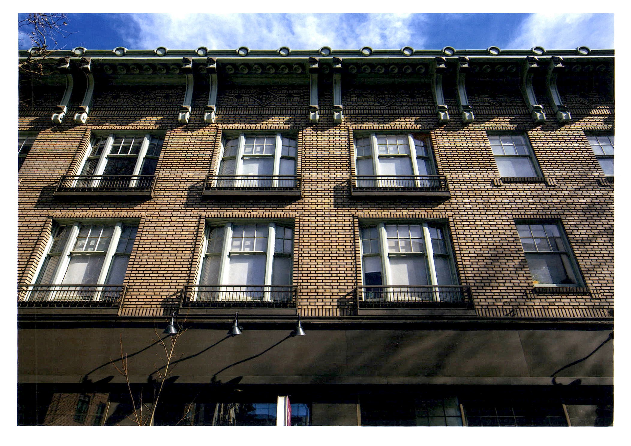 After: Close-up view of front facade looking up after blonde brick cleaning and trim repainting.